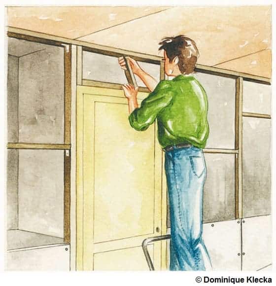 Illustration d'un homme entrain de visser le tasseau du haut de la porte