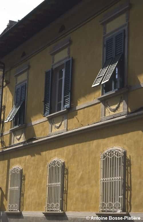 Maison jaune avec des volets et persiennes contre le soleil