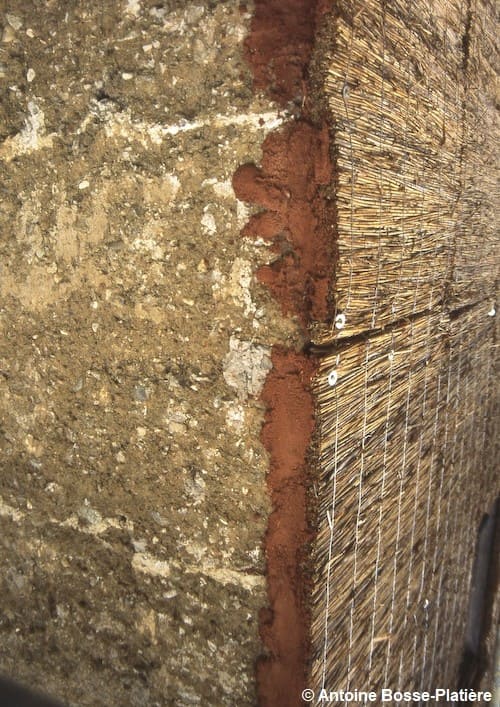 Isolation extérieure d'un mur en pisé par des panneaux de roseaux