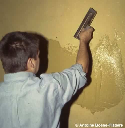 Lissage de l'enduit sur le mur avec une taloche