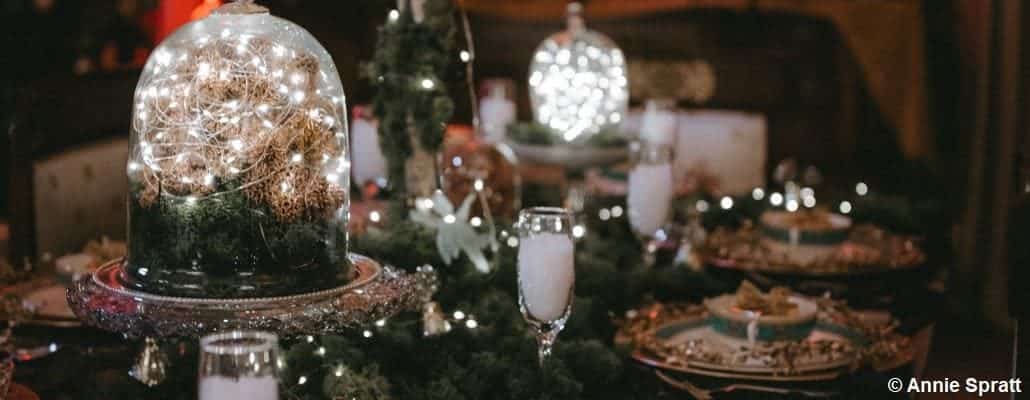 Table de noël avec petites lumières, assiettes et couverts