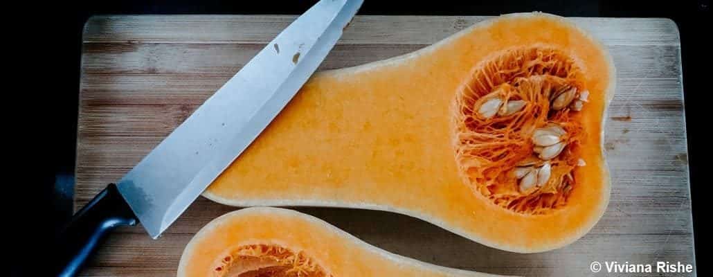 Courge Butternut coupée en deux avec un couteau posé dessus