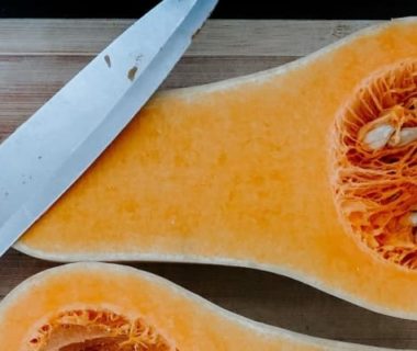 Courge Butternut coupée en deux avec un couteau posé dessus