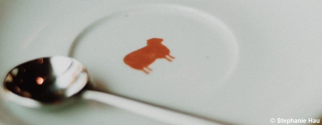 Assiette avec un mouton orange dessiné dessus et une cuillère à côté