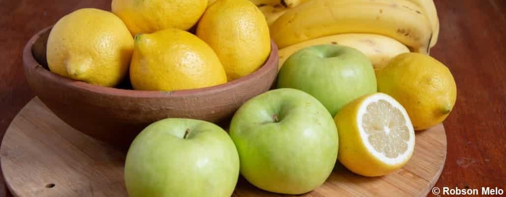 Pommes et citrons sur une planche en bois et dans un saladier