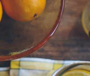 Vue en plongée d'oranges dans un saladier et d'une cuillère à miel