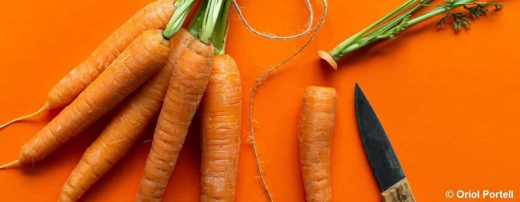 Quelques carottes et un couteau sur fond orange