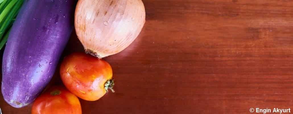 Aubergine, tomates et oignon sur un plan de travail