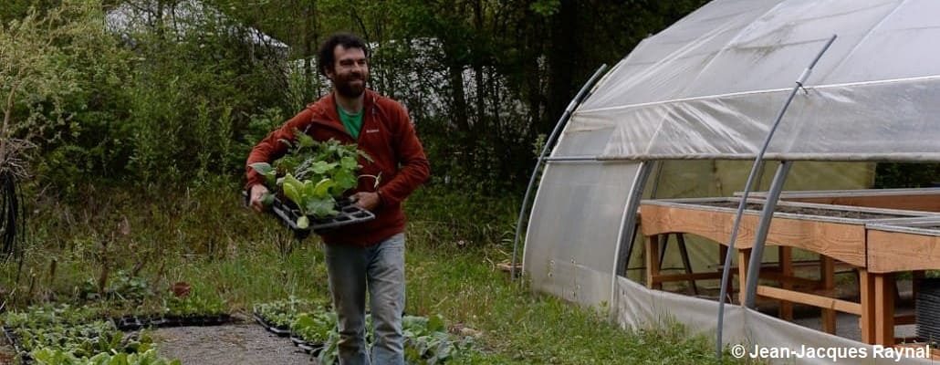 Pascal Aspe qui transporte des plants à côté de la pépinière